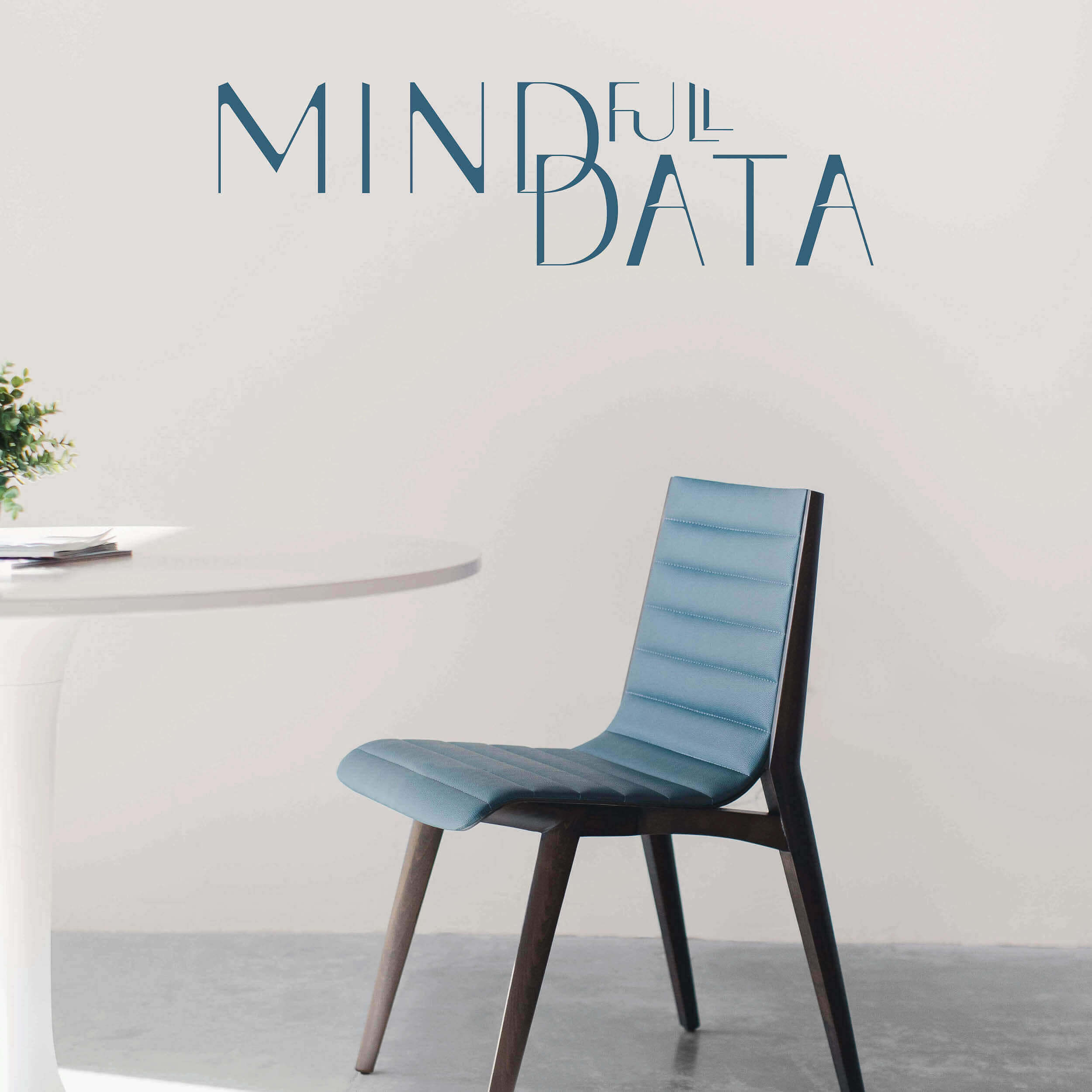 Das Logo (ein Teil des Branding) von MINDfull DATA an einer Wand über einem Tisch mit Stuhl