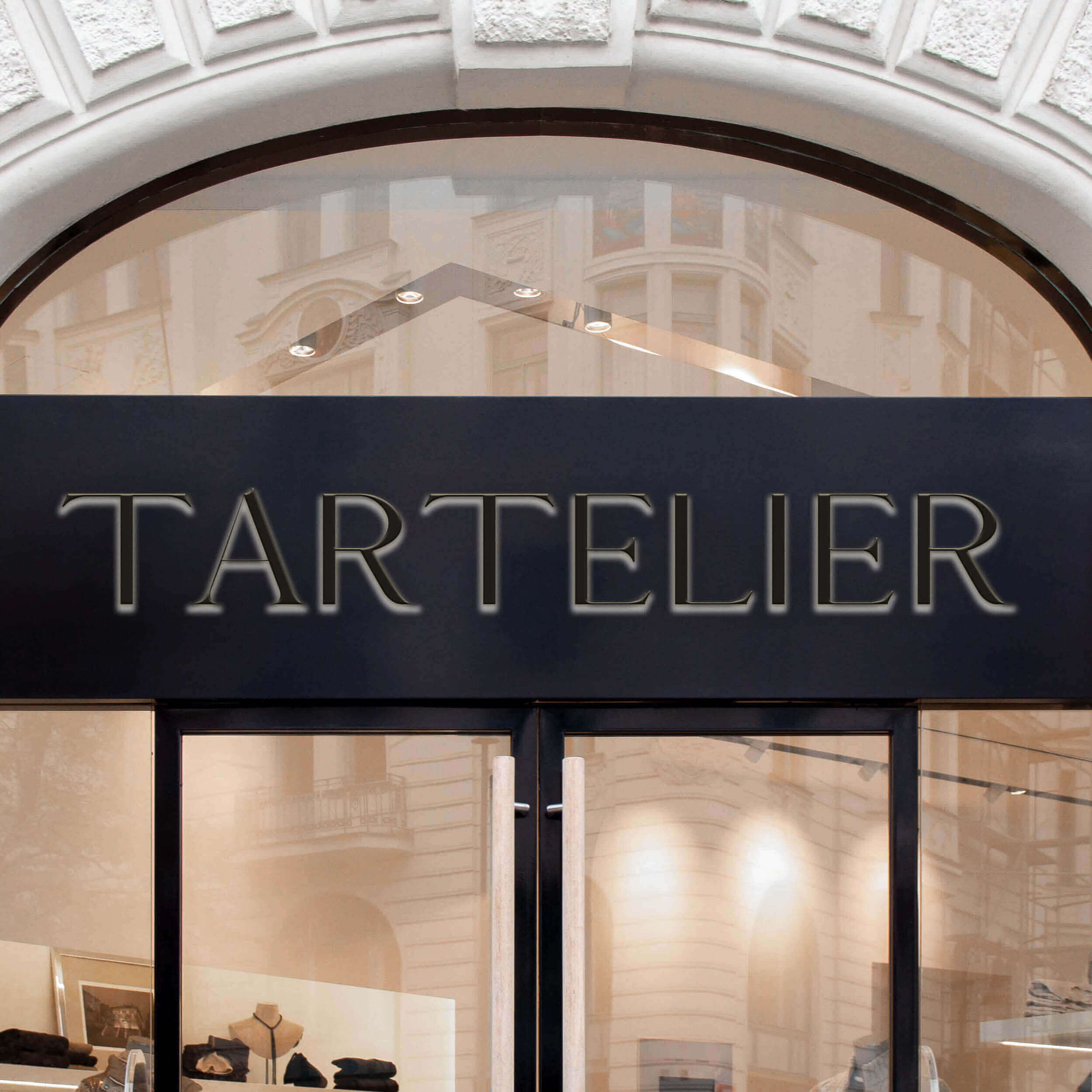 Das Logo von TARTELIER, das durch Branding Stuttgart entstand, über einer Eingangstür zu einem Laden.