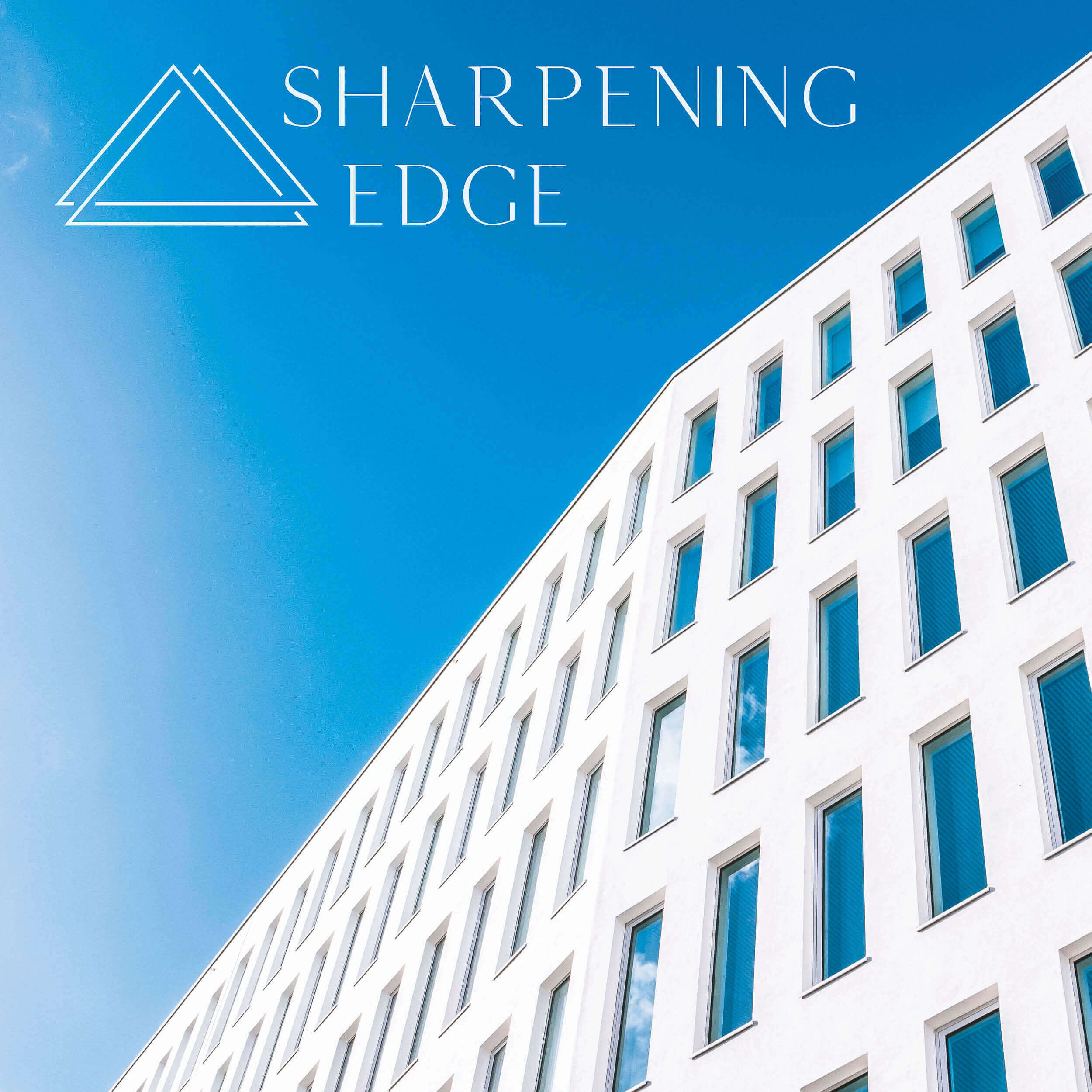 Das Logo von Sharpening Edge, das durch den Service Logoentwicklung Esslingen entstand. Das Logo liegt auf einem Foto von einem weißen Gebäude.