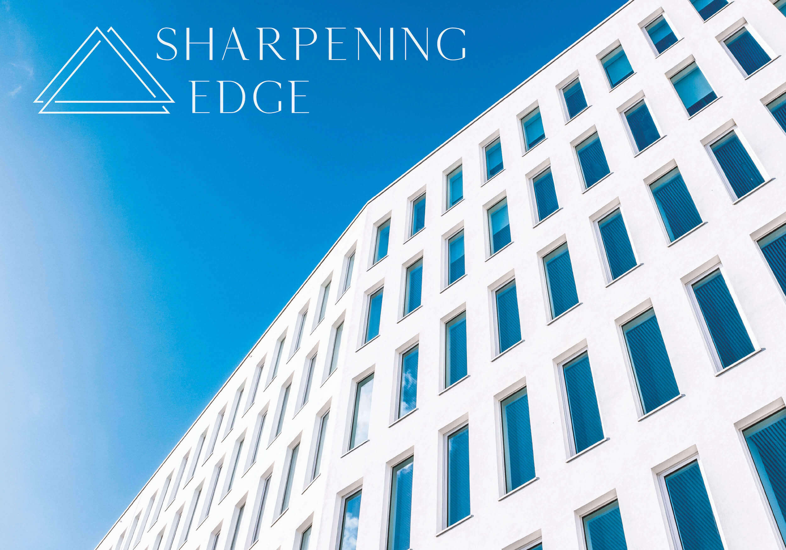 Logo aus dem Kommunikationsdesign für Sharpening Edge auf blauem Himmel über einem Gebäude
